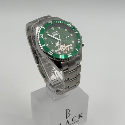 Green wristwatch with silver case on a clear stand against a white background