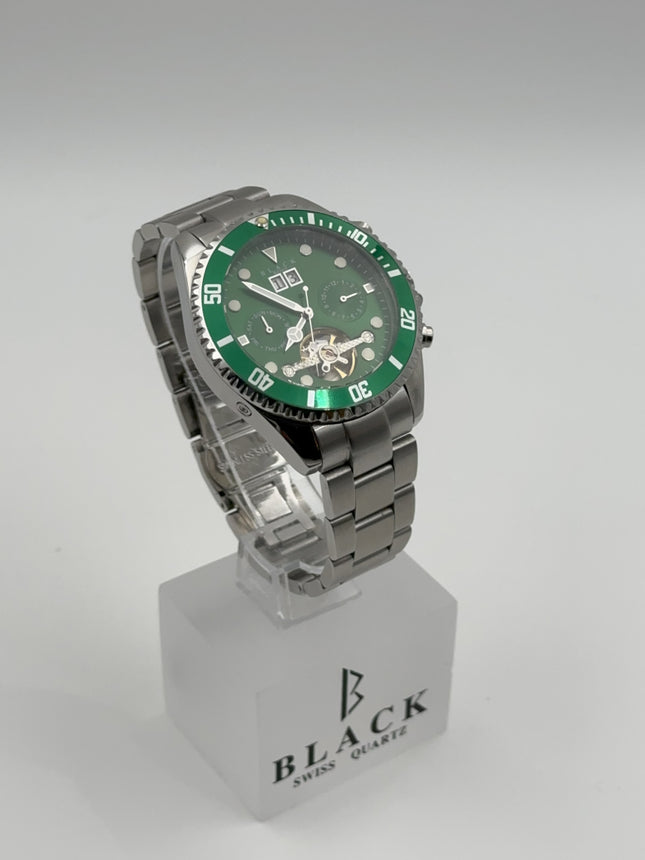 Green wristwatch with silver case on a clear stand against a white background