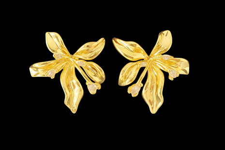 Pair of gold floral earrings on a black background