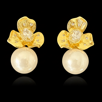 Gold floral earrings with pearl drops on a black background