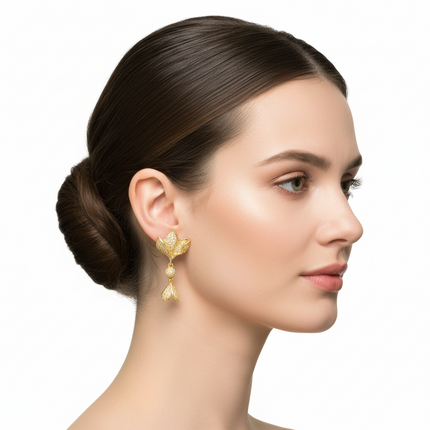 Woman wearing gold earrings with a plain background