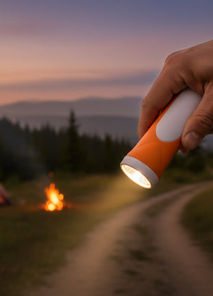 Orange flashlight with white top on a white background