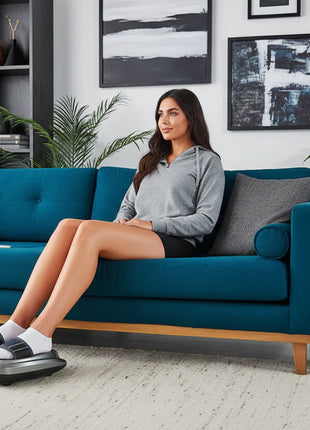 Woman using a foot massager in a living room with promotional text overlay.
