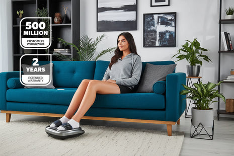 Woman using a foot massager in a living room with promotional text overlay.