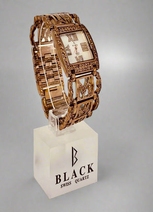 Gold wristwatch on a white stand with 'Black Swiss Quartz' branding against a gray background