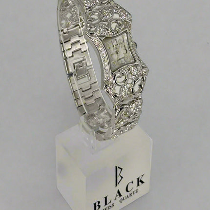 Silver bracelet on a stand with 'Black Swiss Quartz' branding against a gray background