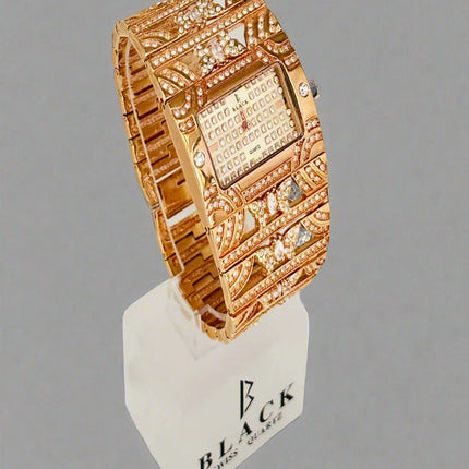 Gold wristwatch with intricate design on a gray background