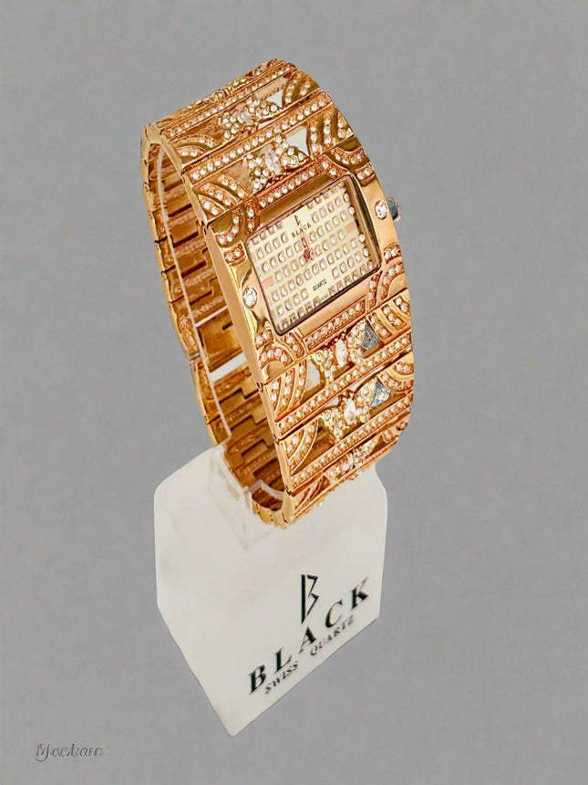 Gold wristwatch with intricate design on a gray background