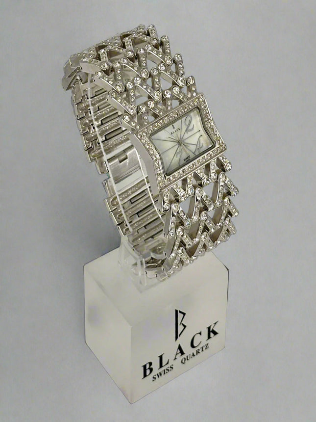 Silver bracelet watch on a stand with 'Black Swiss Quartz' branding