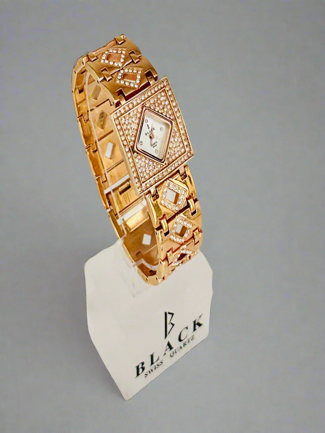 Gold bracelet with diamond accents on a white stand against a gray background