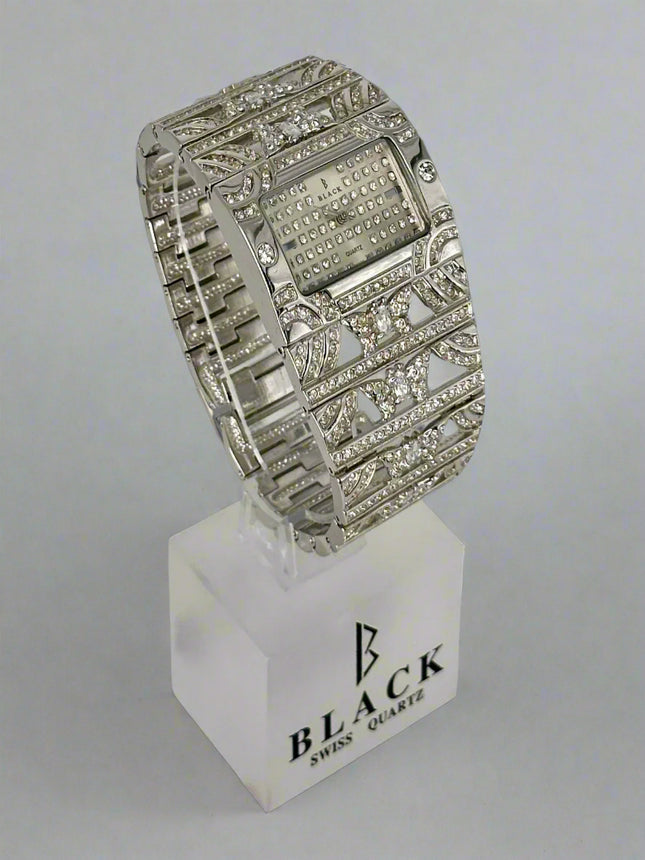 Silver wristwatch with decorative band on a white stand featuring 'Black Swiss Quartz' branding.