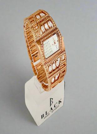Rose gold watch on a display stand with a gray background