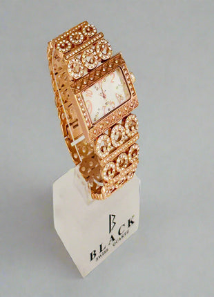 Rose gold watch on a white stand with a light gray background