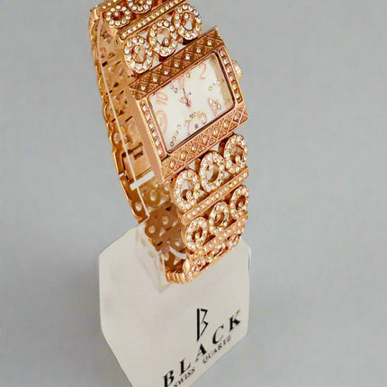 Rose gold watch on a white stand with a light gray background