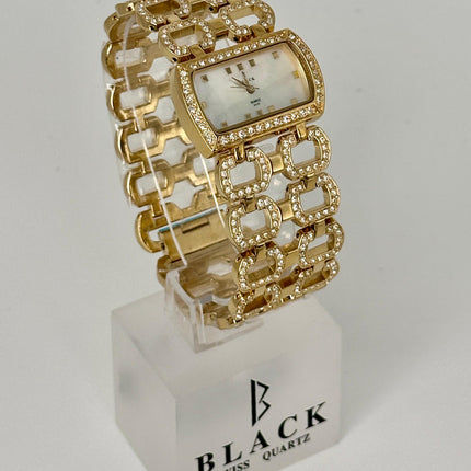 Gold bracelet watch on a white stand with 'Black Swiss Quartz' branding.