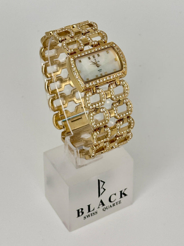 Gold bracelet watch on a white stand with 'Black Swiss Quartz' branding.