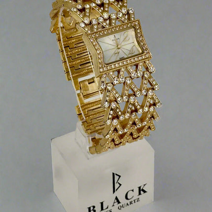 Gold ornate watch on a white stand with 'Black Swiss Quartz' branding