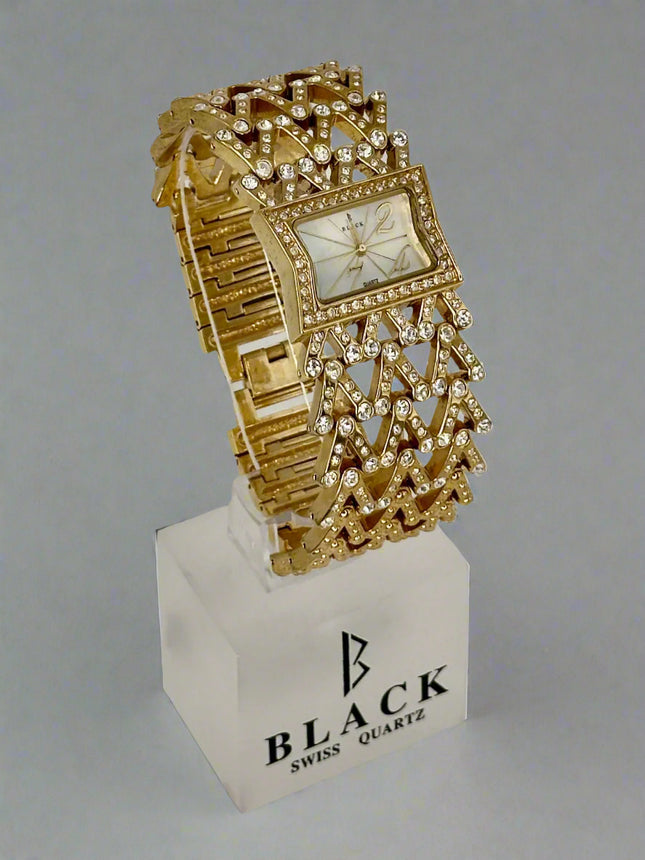 Gold ornate watch on a white stand with 'Black Swiss Quartz' branding