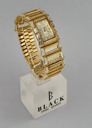 Gold wristwatch with intricate design on a gray background