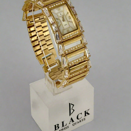 Gold wristwatch with intricate design on a gray background