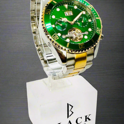 Green and silver watch on a white stand with 'Black Swiss Quartz' branding.