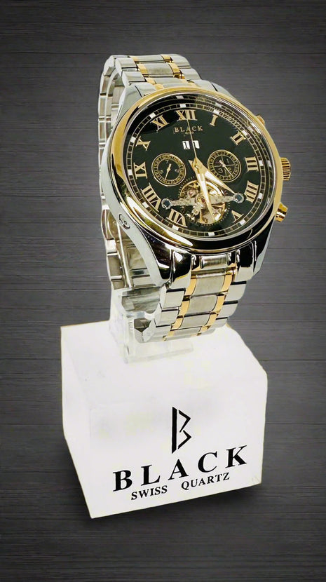 Two-tone watch with black face and gold accents on a white stand with 'BLACK' branding.