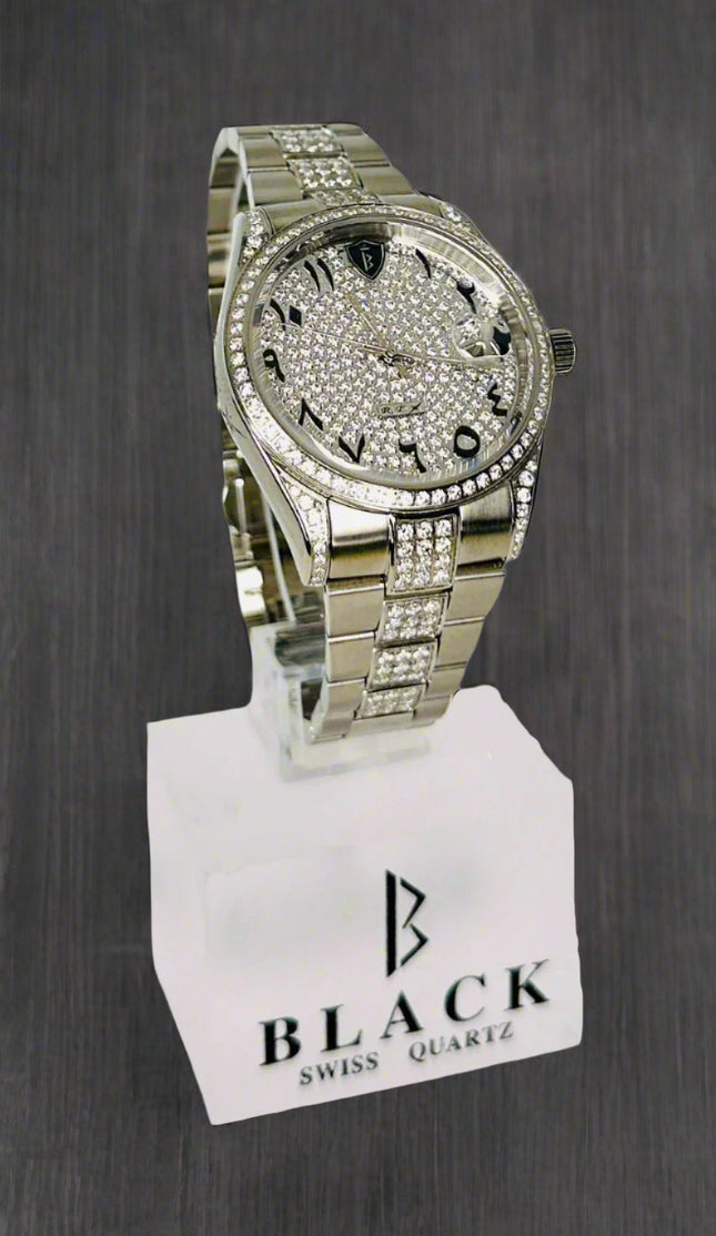 Silver watch with gemstones on a stand displaying 'Black Swiss Quartz'.