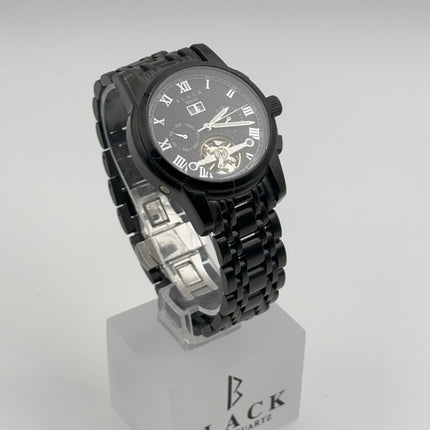 Black wristwatch on a white stand with 'BLACK' branding