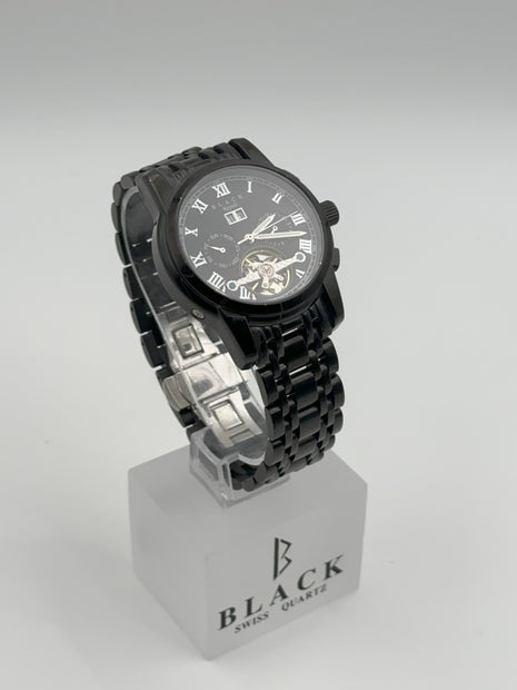 Black wristwatch on a white stand with 'BLACK' branding