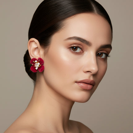 Woman wearing a red floral earring against a neutral background