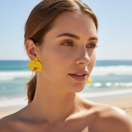 Woman wearing yellow flower earrings on a beach