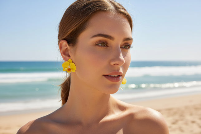 Woman wearing yellow flower earrings on a beach