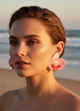 Woman wearing pink flower earrings on a beach