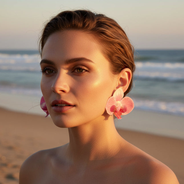 Woman wearing pink flower earrings on a beach