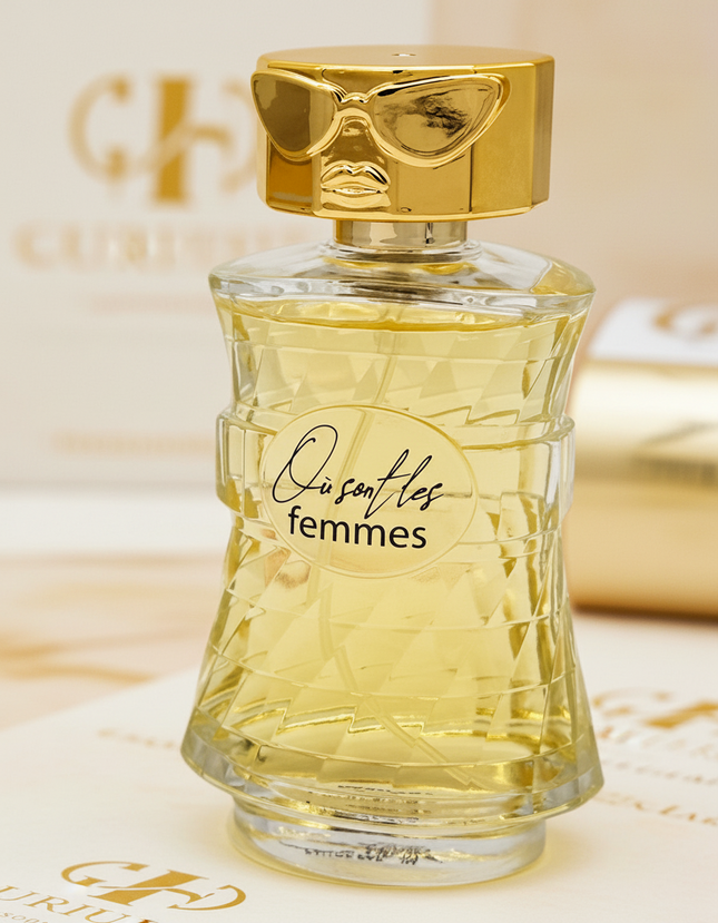Perfume bottle labeled 'Ousafles femmes' with gold cap on a white background