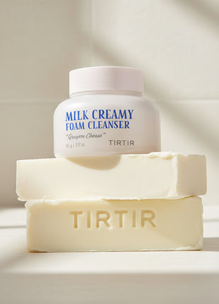 Milk Creamy Foam Cleanser by TIRTIR with a sample of cleanser on a white background