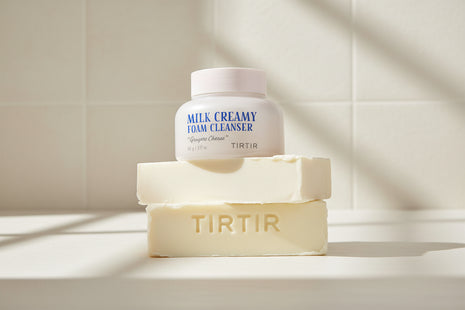 Milk Creamy Foam Cleanser by TIRTIR with a sample of cleanser on a white background